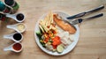 Grilled salmon fish and baked cod fish decorated with various vegetables corn carrot peas lemon french fries and sauces Royalty Free Stock Photo