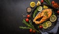 Grilled salmon fish with seasoning and various vegetables on black stone background Royalty Free Stock Photo