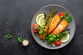 Grilled salmon fish steak, asparagus, tomato and corn salad on plate. Healthy dish for lunch Royalty Free Stock Photo