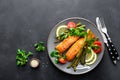 Grilled salmon fish steak, asparagus, tomato and corn salad on plate. Healthy dish for lunch