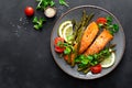 Grilled salmon fish steak, asparagus, tomato and corn salad on plate. Healthy dish for lunch Royalty Free Stock Photo