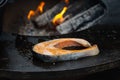 Grilled salmon fish with various vegetables on the flaming grill