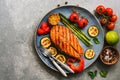 Grilled salmon fish with vegetables zucchini, asparagus, tomato, sweet pepper on a plate, gray background. Top view, flat lay,copy Royalty Free Stock Photo