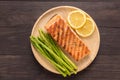 Grilled salmon with lemon, asparagus on the wooden background Royalty Free Stock Photo