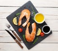 Grilled salmon, salad and condiments on wooden table Royalty Free Stock Photo