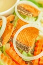 Grilled salmon with salad, onion slice rings, carrot, boiled egg and salad dressing served on white plate. Homemade and healthy Royalty Free Stock Photo