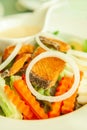 Grilled salmon with salad, onion slice rings, carrot, boiled egg and salad dressing served on white plate. Homemade, healthy food Royalty Free Stock Photo