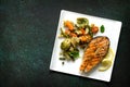 Grilled salmon steak, couscous and vegetables on stone or concrete table. Healthy proper nutrition. Royalty Free Stock Photo