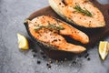 Grilled salmon steak with herbs and spices rosemary lemon on wooden cutting board background - Close up cooked salmon fish fillet Royalty Free Stock Photo