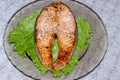 Grilled salmon steak laid on a transparent plate