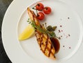 Grilled salmon steak with lemon and cherry tomatoes. View from a