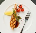 Grilled salmon steak with lemon and cherry tomatoes. View from a