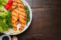 Grilled salmon steak served with grilled tomatoes, salad, lemon sliced, pepper seeds, rosemary, parsley Royalty Free Stock Photo