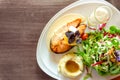 Grilled salmon steak sliced on white plate with mixed vegetable salad, mashed potatoes and topping in a glass, food in dish