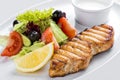 Grilled salmon steak with vegetables. On a white plate Royalty Free Stock Photo