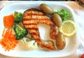 Grilled salmon steak with vegetables on a white plate Royalty Free Stock Photo