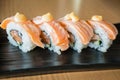 Grilled salmon sushi roll, japanese food style on black ceramic Royalty Free Stock Photo