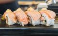 Grilled salmon sushi roll, japanese food style on black ceramic Royalty Free Stock Photo