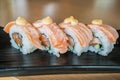 Grilled salmon sushi roll, japanese food style on black ceramic Royalty Free Stock Photo