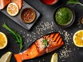 Grilled salmon topped with sesame seeds and surrounded by sauce and various toppings Royalty Free Stock Photo