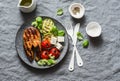 Grilled salmon, zucchini, baked cherry tomatoes and silky tofu - healthy balanced meal on grey background