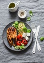 Grilled salmon, zucchini, baked cherry tomatoes and silky tofu - healthy balanced meal on grey background Royalty Free Stock Photo