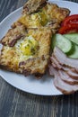 Grilled sandwich with egg, vegetables and bacon on a dark wooden background. Tasty breakfast Royalty Free Stock Photo