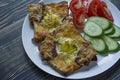 Grilled sandwich with egg, vegetables and bacon on a dark wooden background. Tasty breakfast Royalty Free Stock Photo