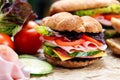 Grilled Sandwich with lettuce, slices of fresh tomatoes, cucumber, red onion, salami, ham and cheese. Royalty Free Stock Photo