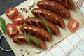 Grilled sausage with the addition of herbs and vegetables on the grill plate, outdoors. Royalty Free Stock Photo