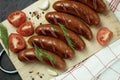 Grilled sausage with the addition of herbs and vegetables on the grill plate, outdoors. Grilling food, bbq, barbecue Royalty Free Stock Photo