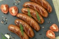 Grilled sausage with the addition of herbs and vegetables on the grill plate, outdoors Royalty Free Stock Photo