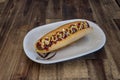 A grilled sausage on a bun with ketchup, mustard and mayo Royalty Free Stock Photo