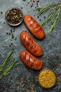 Grilled sausage, mustard and spices on black smokey background Royalty Free Stock Photo