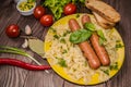 Grilled sausage with pasta, slices of bread, herbs and cherry tomatoes. Top view. On a wooden rustic brown background Royalty Free Stock Photo