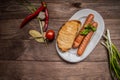 Grilled sausage with pasta, slices of bread, herbs and cherry tomatoes. Top view. On a wooden rustic brown background Royalty Free Stock Photo