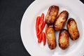 Grilled sausage pork and red chilies on white plate.