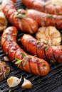 Grilled sausages with the addition of herbs and vegetables on the grill plate, outdoor, close-up Royalty Free Stock Photo