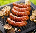 Grilled sausages with the addition of herbs and vegetables on the grill plate, outdoors. Royalty Free Stock Photo