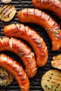 Grilled sausages with the addition of herbs and vegetables on the grill plate, top view, close-up Royalty Free Stock Photo