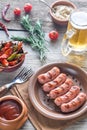 Grilled sausages with appetizers and mug of beer