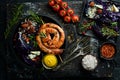 Grilled sausages, and baked red cabbage with cheese, rosemary and cranberries on a black plate. Traditional German dish. Royalty Free Stock Photo