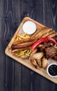 Grilled sausages and chicken on wood board