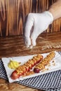 Grilled sausages closeup. The meat dish is sprinkled with dried caramelized onions. Top with grated cheese, mustard and ketchup. Royalty Free Stock Photo