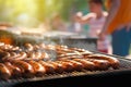 Grilled sausages are cooked on a barbecue grill, outdoor on a bright sunny day