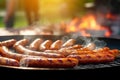 Grilled sausages are cooked on a barbecue grill, outdoor on a bright sunny day