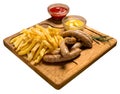 Grilled sausages with french fries with ketchup and mustard on a wooden stand. Isolated image on a white background Royalty Free Stock Photo