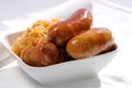 Grilled sausages, potatoes and sauerkraut in a white plate Royalty Free Stock Photo