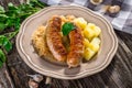 Grilled sausages, potatoes and sauerkraut Royalty Free Stock Photo