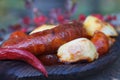 Grilled sausages with potatoes on wooden plate
